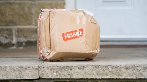 Paket aus Karton vor einer Haustür
