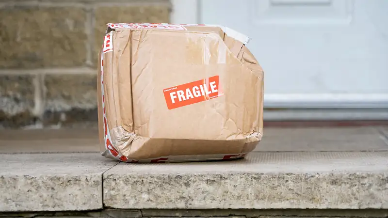 Paket aus Karton vor einer Haustür