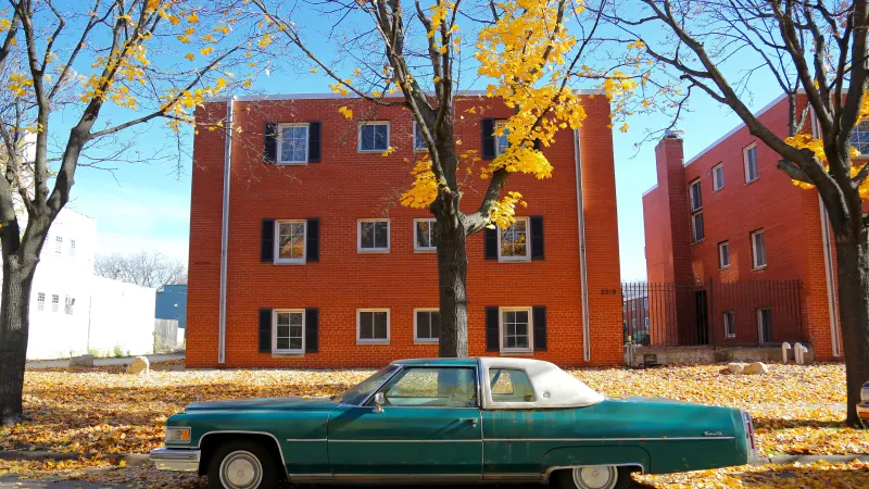 Blaugrünes Auto, an einer Straße im Herbst geparkt