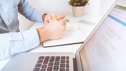 Person im Büro, die Notizen auf Papier schreibt