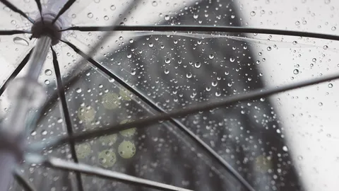 Durchsichtiger Regenschirm mit Regentropfen, von unten gesehen