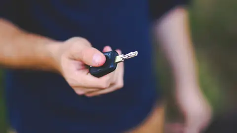 Hand, die einen Schlüssel übergibt